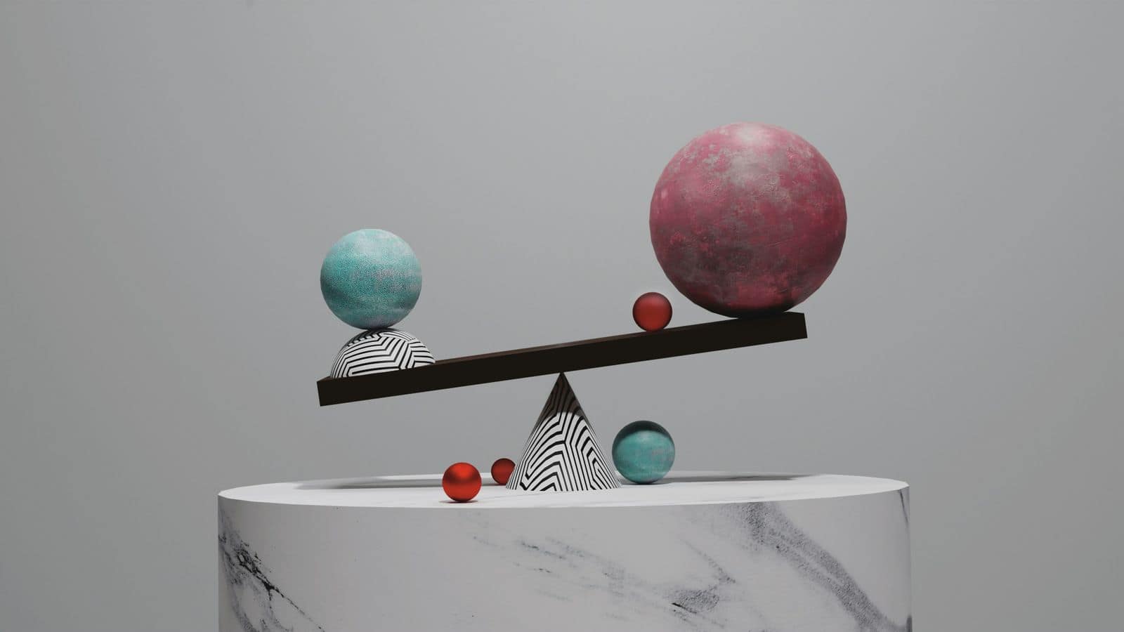 A balance scale weighing spheres of different sizes